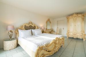a bedroom with a large white bed and a mirror at Altstadt Hotel Magic Luzern in Lucerne