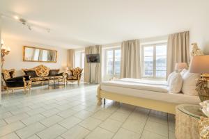ルツェルンにあるアルトシュタット ホテル マジック ルツェルンのベッドルーム(大型ベッド1台付)、リビングルームが備わります。