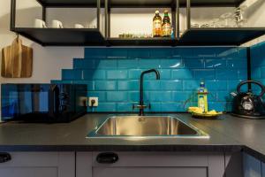 - une cuisine avec un évier et du carrelage bleu dans l'établissement Ruhiges Apartment Ettlingen, à Ettlingen