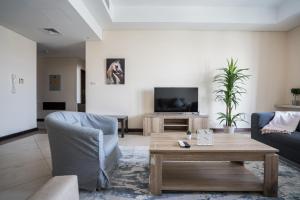 a living room with a coffee table and a tv at HiGuests - Incredible City Views in Deira 5-min to Airport in Dubai