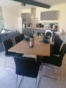 una mesa de madera con sillas negras en la cocina en Gîte L'âme Du Gourmand en Pontorson