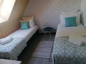 2 camas individuales en una habitación con ventana en Gîte L'âme Du Gourmand en Pontorson