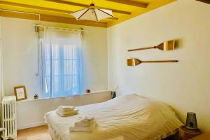 a bedroom with a bed with towels on it at Le clos jasmin - quartier historique de Montlouis in Montlouis-sur-Loire