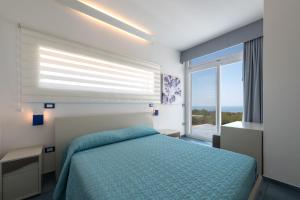 sypialnia z łóżkiem i dużym oknem w obiekcie Fani Luxury Villas w mieście Torre Pali +37 zdjęć