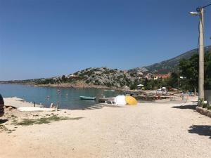 a beach with a group of people in the water at 35 meters from sea Sweat house with garden in Karlobag +31 photos