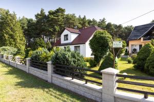 a fence in front of a house with bushes at Ferienhaus Am Sägewerk in Malschwitz