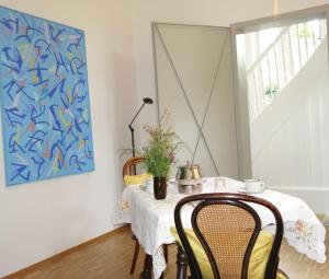 une salle à manger avec une table, des chaises et un tableau dans l'établissement Bed & Breakfast Grünes Gold am Leisberg, à Baden-Baden