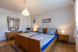 a bedroom with a bed with blue sheets and a mirror at Ferienhaus Am Sägewerk in Malschwitz