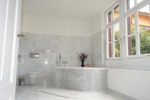 uma casa de banho branca com uma banheira e um WC em Bed & Breakfast Grünes Gold am Leisberg em Baden-Baden