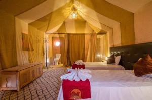 1 dormitorio con 1 cama grande con dosel en Mari Desert Camp, en Merzouga