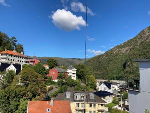 a view of a town with houses and mountains at Kjellerleilighet - nært Haukeland sykehus. in Bergen
