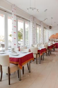 una sala da pranzo con tavoli, sedie e finestre di Hotel Vali Dramalj a Crikvenica