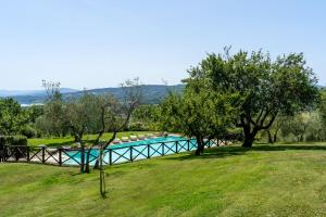 ein Pool auf einem Feld mit Bäumen in der Unterkunft Poggio Agli Ulivi in Barberino di Mugello