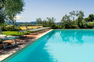 a swimming pool with chaise lounge chairs and a swimming pool at Poggio Agli Ulivi in Barberino di Mugello