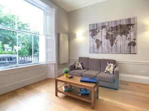 ein Wohnzimmer mit Sofa und Tisch in der Unterkunft Queen Victoria Apartments in London + 54 Fotos