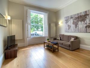 uma sala de estar com um sofá e uma televisão em Queen Victoria Apartments em Londres