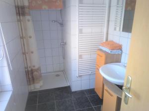 ベルガーエンデ・レートヴィッシュにあるFerienhaus-Poweleitの白いバスルーム(シャワー、シンク付)