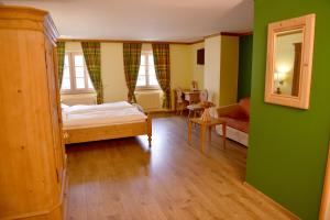 a bedroom with green walls and a bed and a mirror at Hôtel de Ville in Gruyères +79 photos