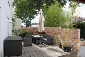 a patio with an umbrella and a table and chairs at Ferienhaus Marina in Weil am Rhein