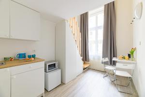 a kitchen with white cabinets and a table with a microwave at Crystal Downtown Apartments in Budapest