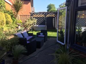 un patio con 2 sillas y una pérgola en The Edwardian Lodge Guest House, en Salisbury