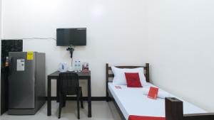 Habitación con cama y mesa con nevera. en RedDoorz at MBB Room NAIA 2 en Manila