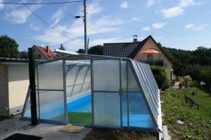 a glass house with a pool in the backyard at Ferienhaus Belvedere in Hainewalde