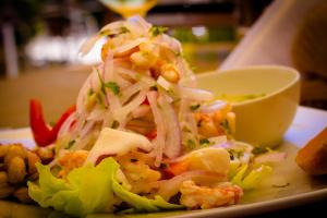 une assiette de nourriture avec une salade sur une table dans l'établissement Hotel Casa Mediterranea Mancora, à Máncora