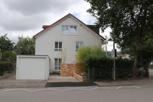 une maison blanche avec un grand garage blanc dans l'établissement Ferienhaus Marina, à Weil am Rhein