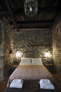 a bedroom with a bed in a stone wall at Casa Aulivo in Caiazzo