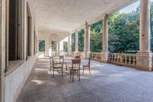 un patio con sillas y mesas en un edificio en B&B Dal Viceré - Villa Mezzalira, en Bressanvido