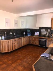 a large kitchen with wooden cabinets and appliances at Villa les 3 lumières 8-10 personnes, Clim, piscine à proximité des plages in La Ciotat