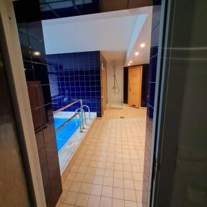 a bathroom with a tub and a tile hallway at Marine Hotel Jūrmala in Jūrmala