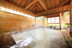 ein Wasserpool in einem großen Holzhaus in der Unterkunft EN RESORT Re'Cove Hakone in Hakone