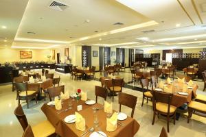 a dining room with tables and chairs and a restaurant at Best Western Plus Salmiya in Kuwait