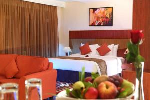 a hotel room with a bed and a bowl of fruit at Best Western Plus Salmiya in Kuwait +55 photos