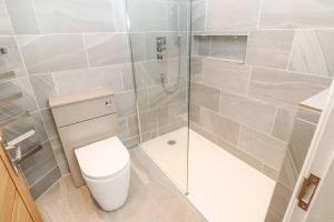 a bathroom with a toilet and a glass shower at Luxurious 4 bedroom Cottage in the Yorkshire Dales in Richmond