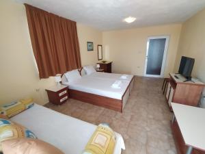 Guest House Polikseni في سوزوبول: غرفه فندقيه سريرين وتلفزيون