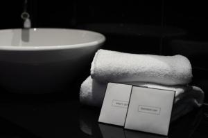 a white towel sitting on top of a sink next to a toothbrush at ROSS Hotel in Stuttgart