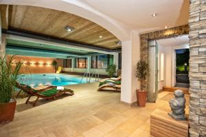 a house with a swimming pool and a patio at Interest Vitalhotel - Partnerbetrieb von Oberstaufen PLUS in Oberstaufen