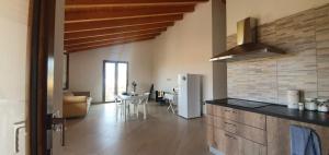 a kitchen with a refrigerator and a table in a room at Villa Piscinas in Piscinas