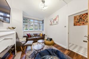 ein Wohnzimmer mit einem Sofa und einem Kamin in der Unterkunft Stunning house in London