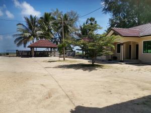 a house with a pavilion and palm trees at Faris's Homestay & Resort in Pasir Puteh