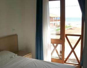 um quarto com uma cama e vista para a praia em Two Bedroom Apartment with Sea View Fogo Residence em Santa Maria