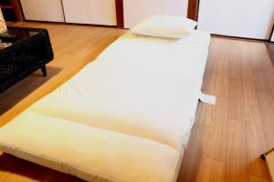 a white bed sitting on top of a wooden floor at リテックス浦安 in Tokyo