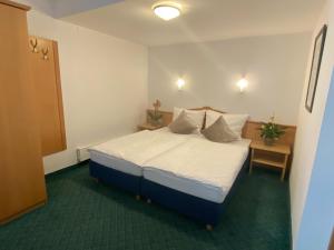 - une chambre avec un lit doté de draps et d'oreillers blancs dans l'établissement Apartment 54, à Sankt Anton am Arlberg