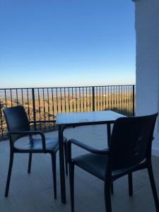 2 Stühle und ein Tisch auf dem Balkon in der Unterkunft Casa Bédar in Bédar