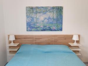 um quarto com uma cama e um quadro na parede em Appartamento Ionios em Noto Marina