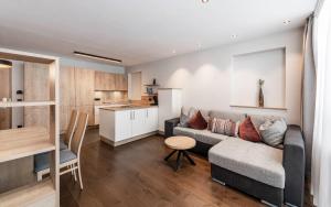 sala de estar y cocina con sofá y mesa en LaMonte Premium Apartments by Feuerstein, en Colle Isarco