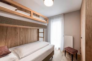 sypialnia z łóżkiem piętrowym i oknem w obiekcie LaMonte Premium Apartments by Feuerstein w mieście Gossensass-Colle Isarco +33 zdjęcia